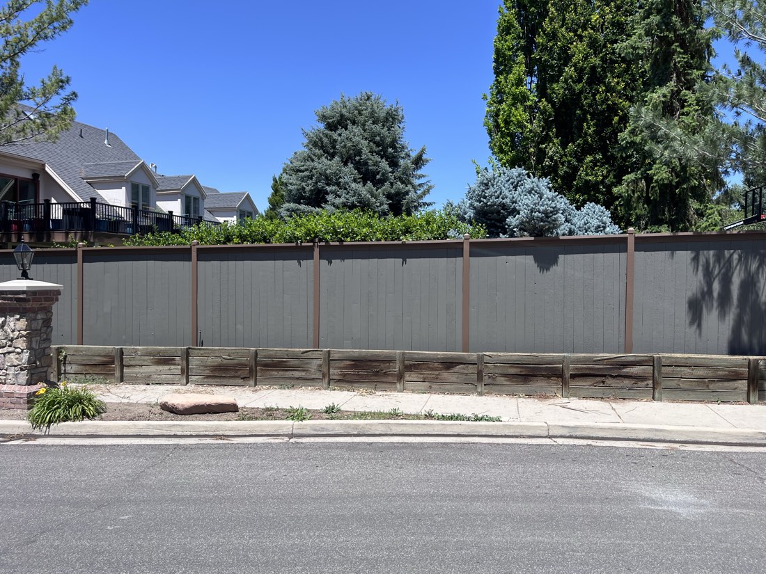 Freshly stained two-tone privacy fence along a Salt Lake City street