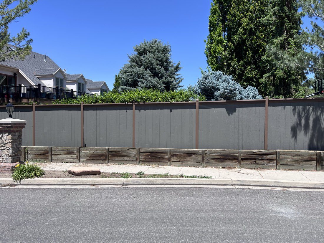 Gray stained wood privacy fence with brown trim along a street in Millcreek, UT
