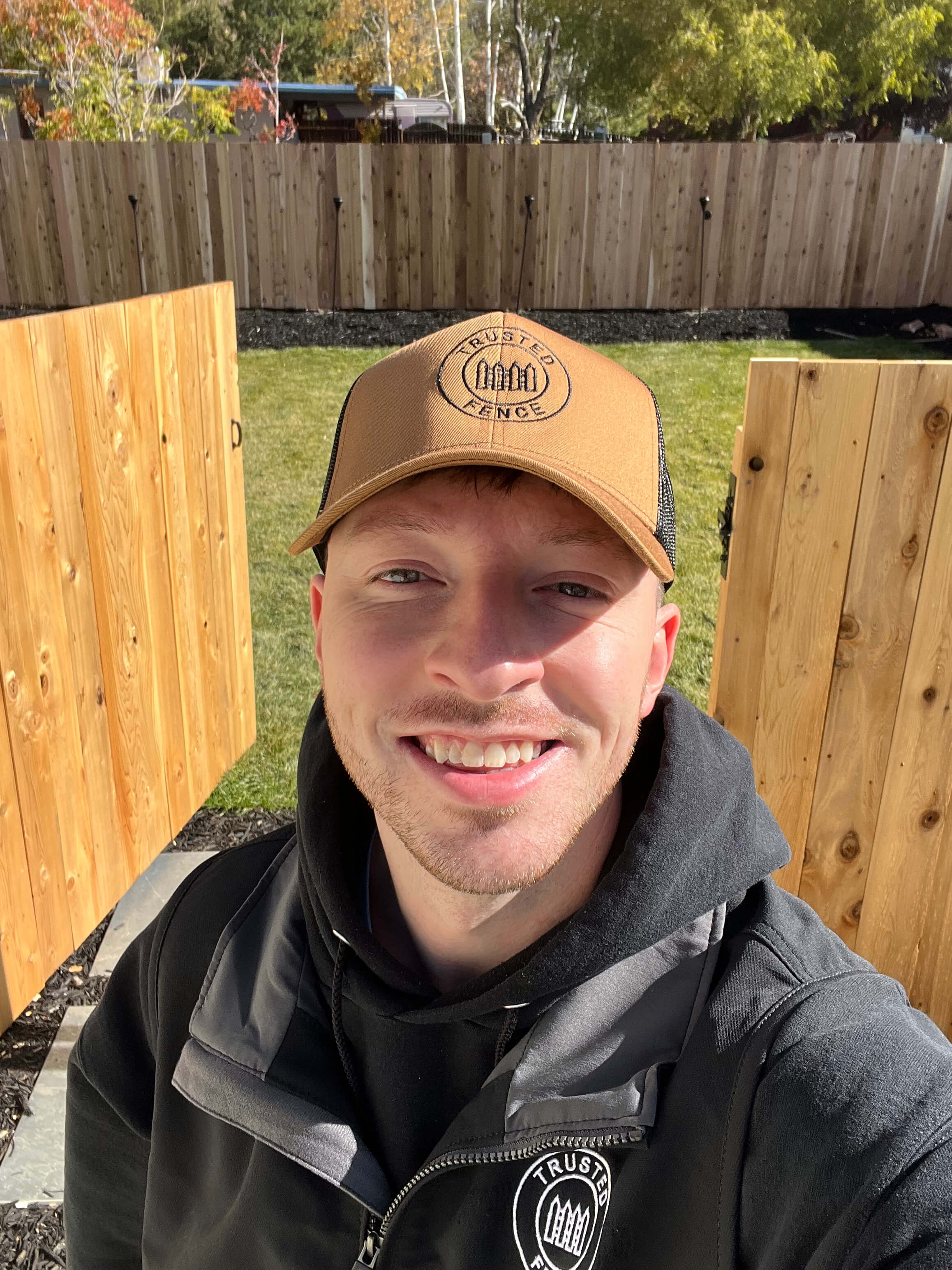 Landon Mickelson, owner of Trusted Fence, in branded gear on a job site