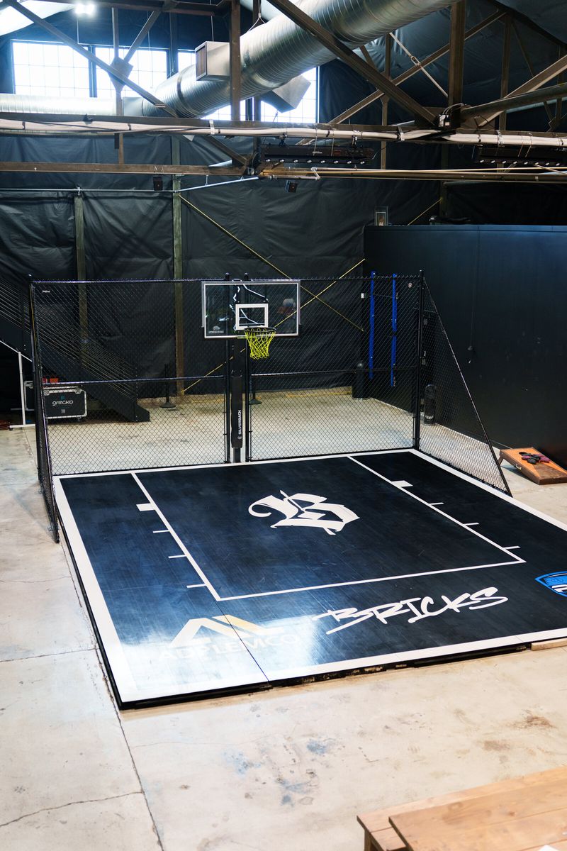 Black chain link cage around an indoor basketball court with a branded floor in Salt Lake City, UT