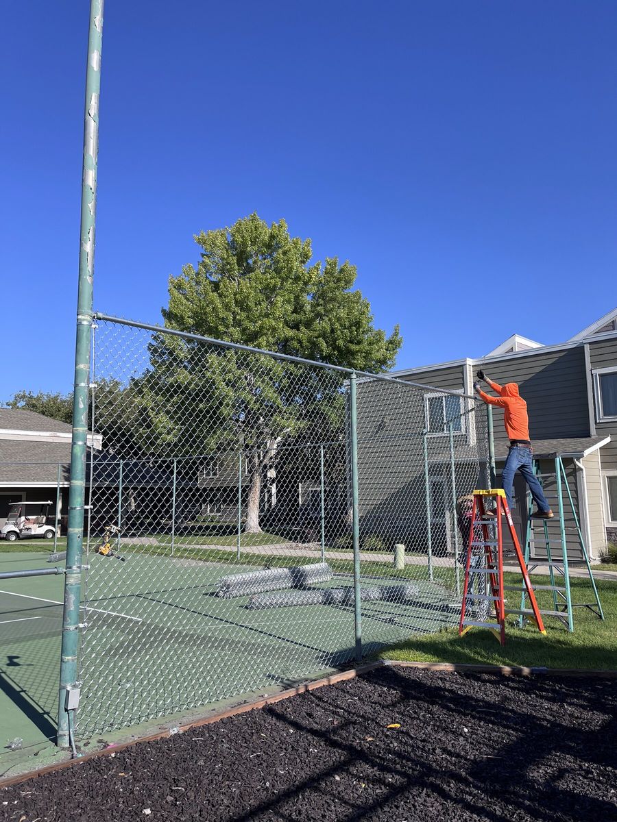Crew installing chain link fence around a sport court in the Salt Lake Valley