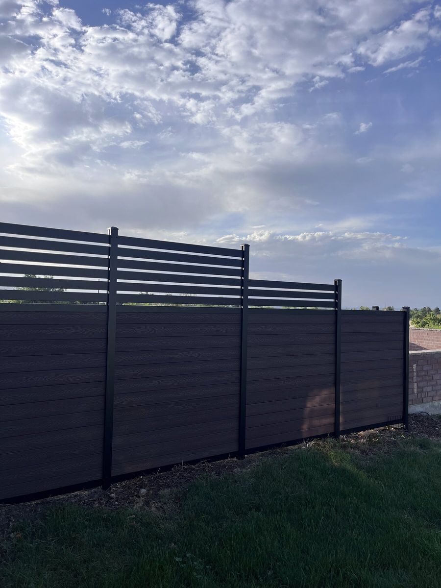 Dark composite privacy fence with a slatted top section in the Salt Lake Valley