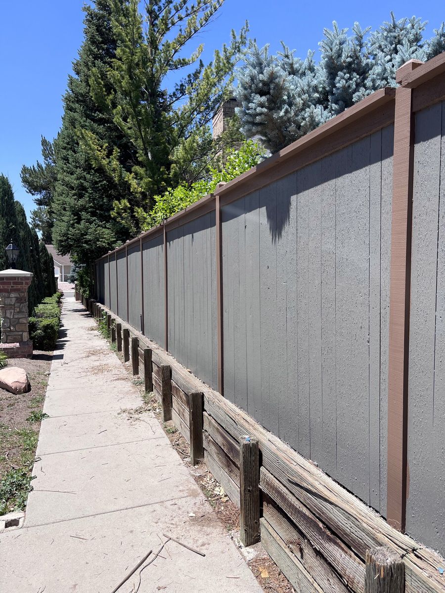 Gray wood privacy fence with brown trim and posts along a sidewalk in Millcreek, UT