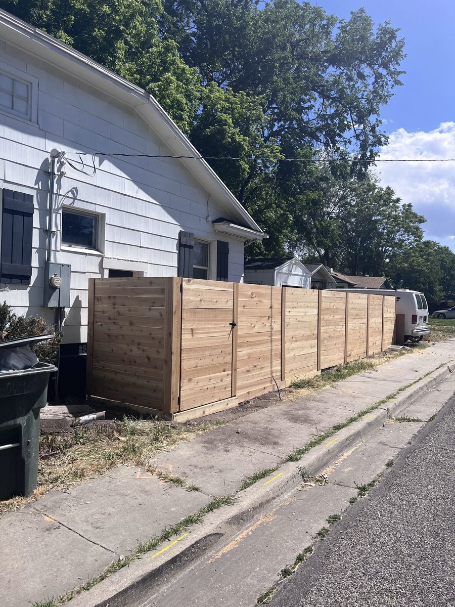Horizontal wood fence with a walk gate beside a white house in Taylorsville, UT